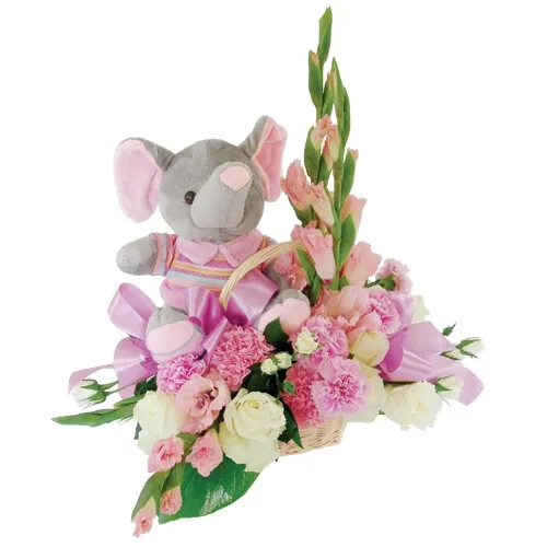 A composition of pink gladiola, white carnations, coloured roses in a basket, a mascot of grey elephant in a pink blouse, flowers for a girl.