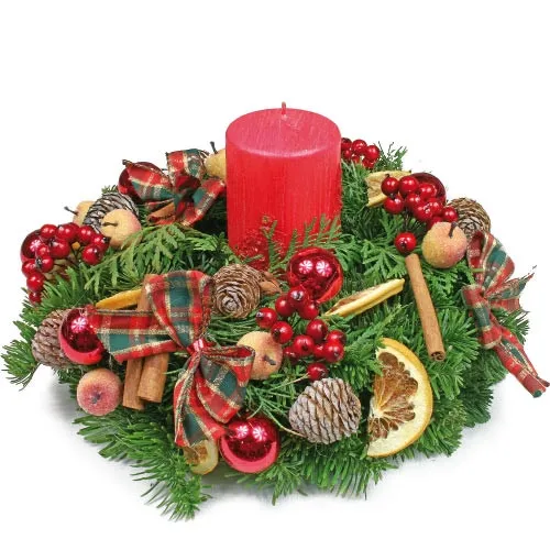 A natural fir and a candle surrounded by fruits and cinnamon is the perfect present for holidays.