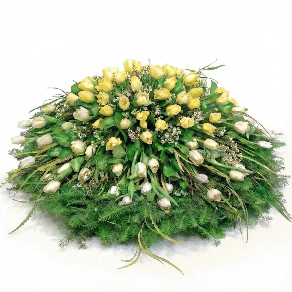 Funeral wreath with tulips, white and yellow tulips with greenery for funerals