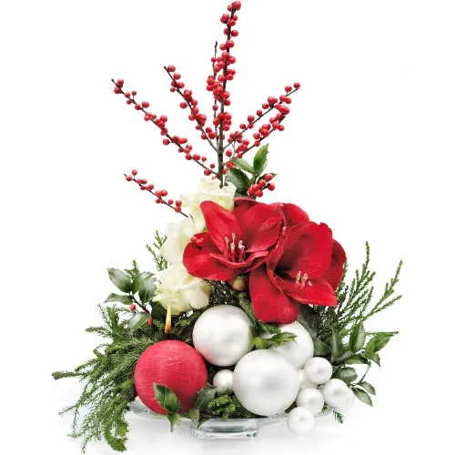 Composition of flowers with amaryllis, ilex, roses and decorative green, white baubles and candles in a ornate jug