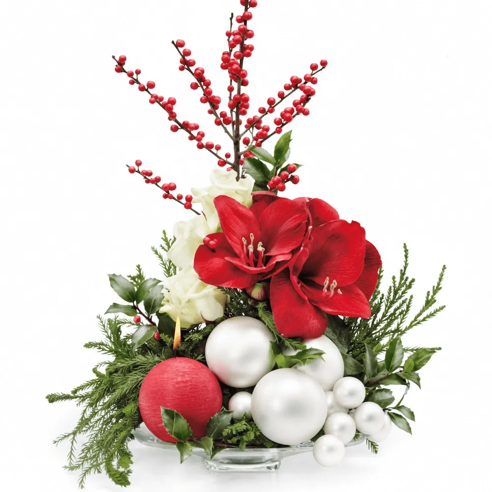 Composition of flowers with amaryllis, ilex, roses and decorative green, white baubles and candles in a ornate jug