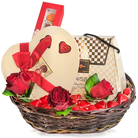 Lady's basket, wicker basket with wine and chocolates, ensemble of wine, chocolate and roses