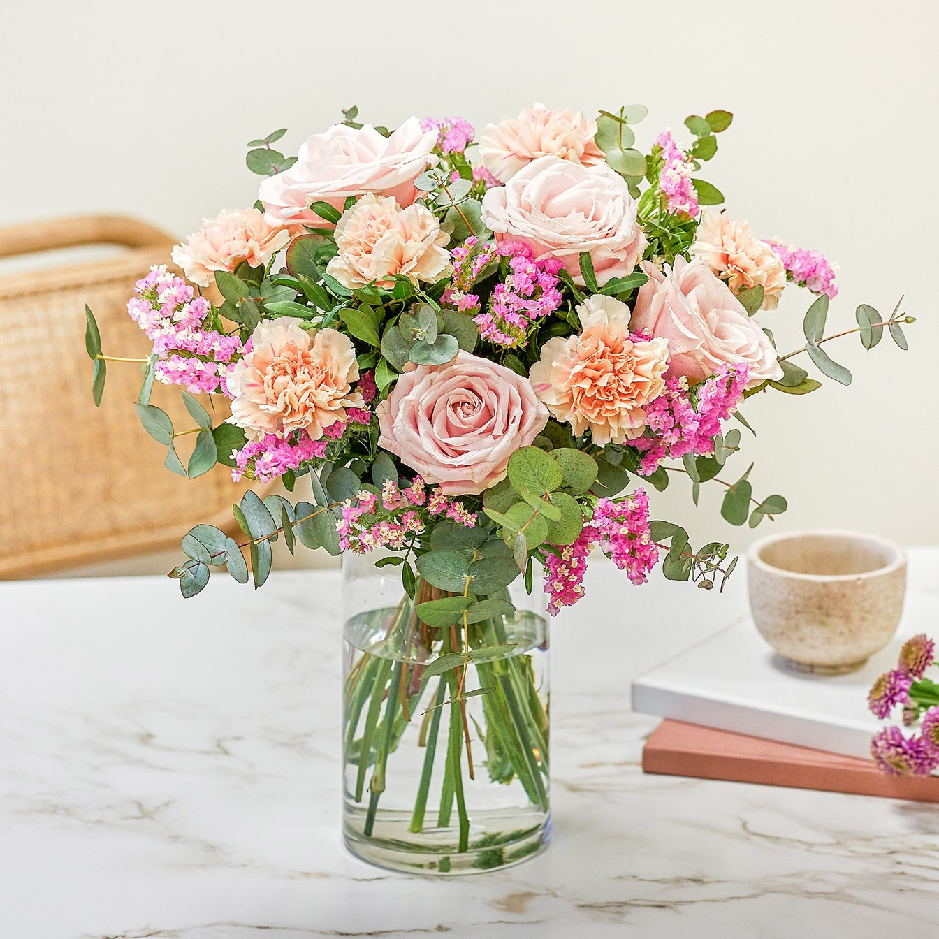 Bukiet łososiowych goździków i różowych róż z zielenią dekoracyjną