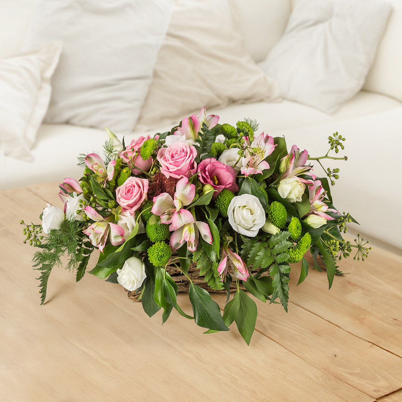 Kompozycja kwiatów w koszu, różowe róże z asltromeriami i białymi dodatkami do Włoch