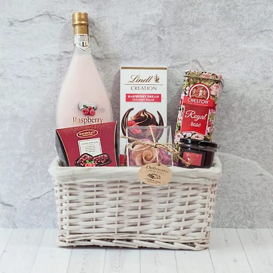 Chocolate rose in a box, honey with raspberry juice, treats in a basket