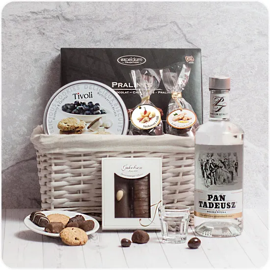 Wicker basket with vodka and sweets for father's day