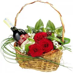 Koszyk z winem, czerwone róże z dekoracją w koszu, czerwone wino z kwiatami w koszyku
