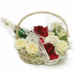 Composition of flowers in a basket with sparkling wine and two glasses, a wedding bouquet, white and red roses, gypsophila 