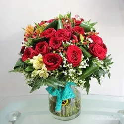 Czerwone róże i kwiaty sezonowe w wazonie 