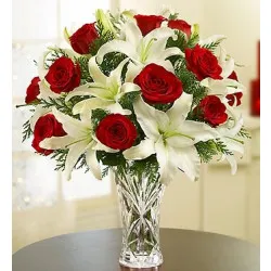 Kompozycja z czerwonych róż i białych lili w wazonie
