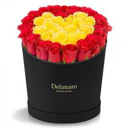 Czerwone i żółte róże w czarnym pudełku serce